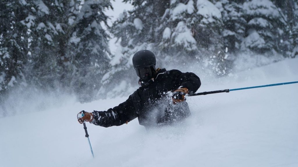 Skier enjoying a deep powder run in Revelstoke, BC's snowy wilderness.
